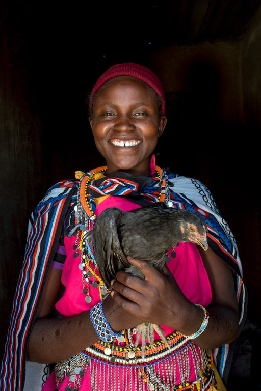 A girl holds a chicken.