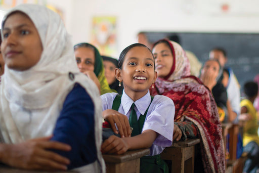 A young girl in Bangladesh sits in class with her peers alert and engaged in learning
