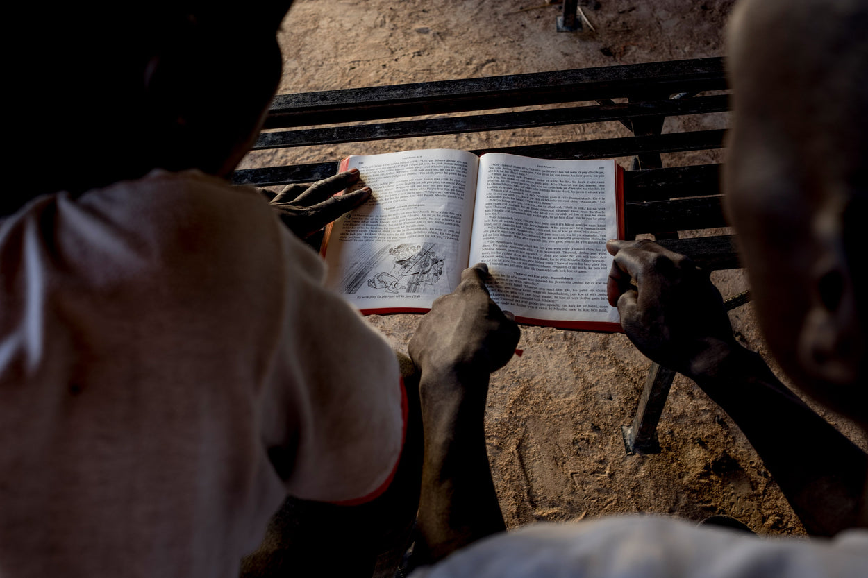 two men looking down and reading a Bible