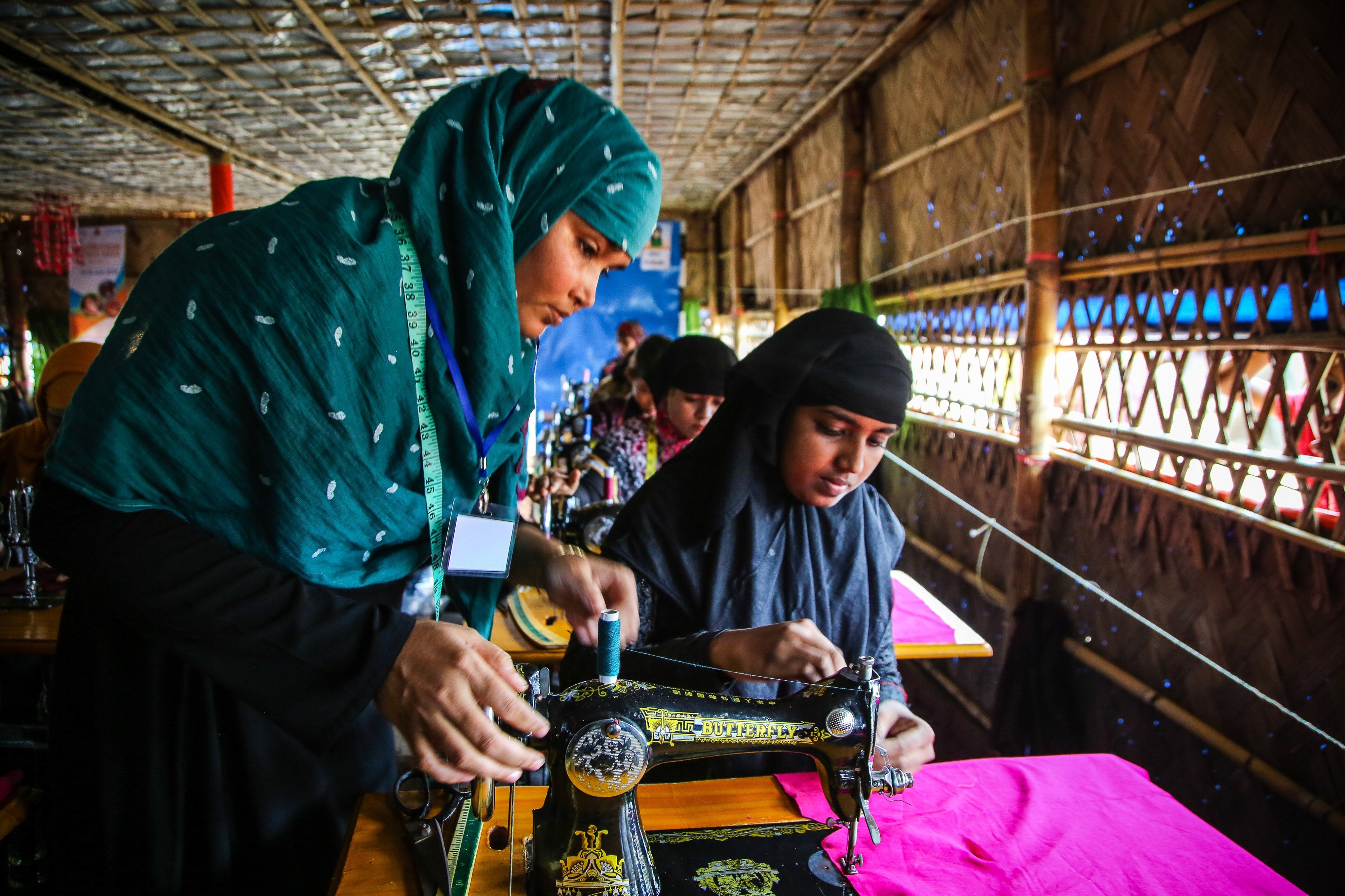 two women looking down at a sewing machine