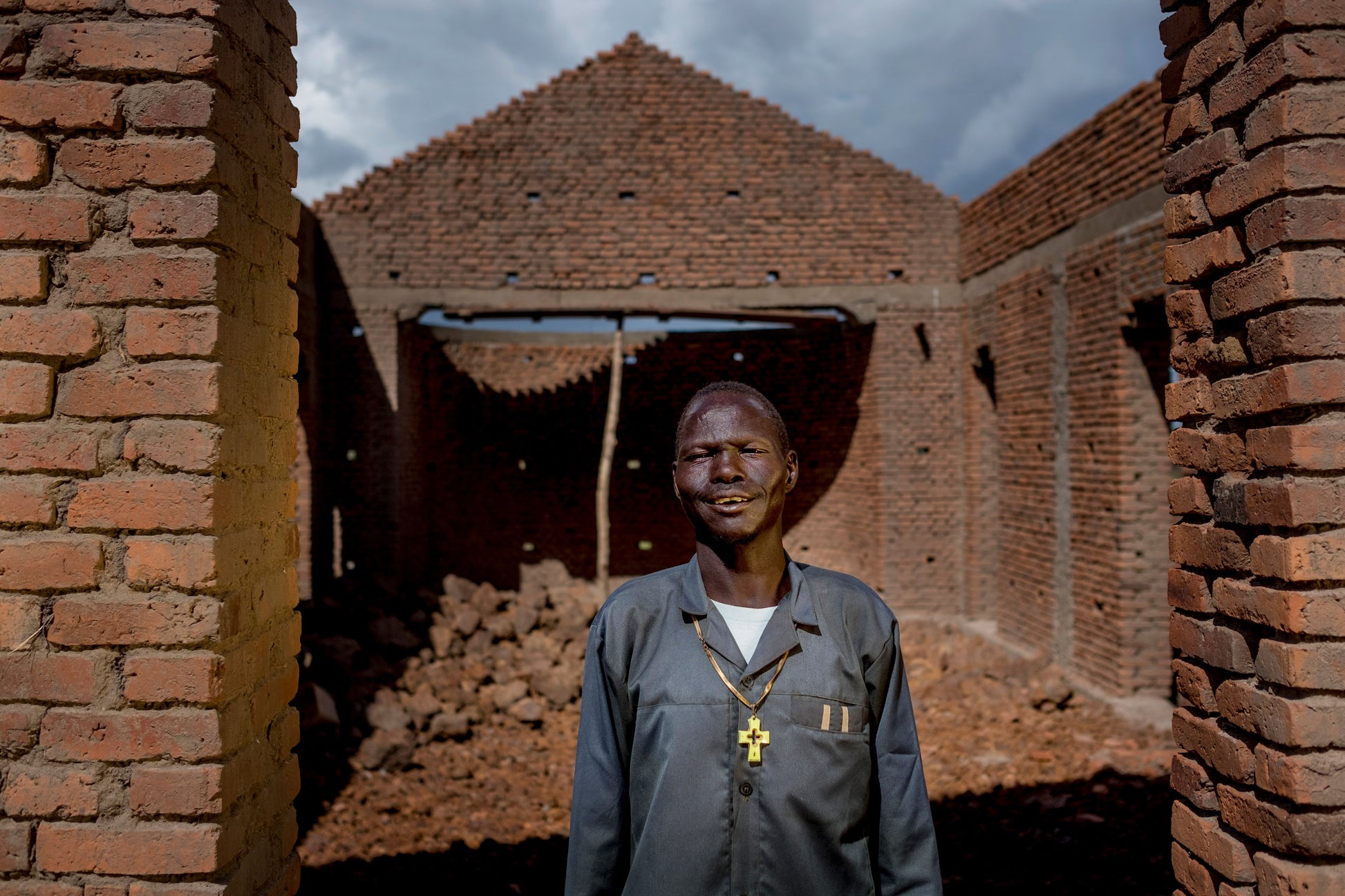 a pastor standing in front of a brick building