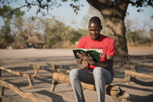 A young man reads a bible.